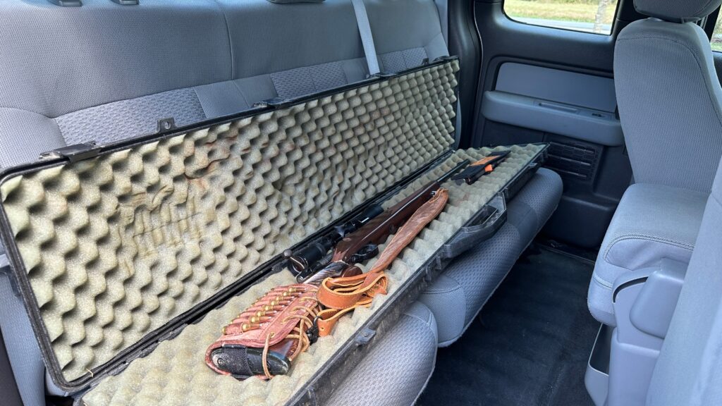 rifle in a case in the backseat of a truck